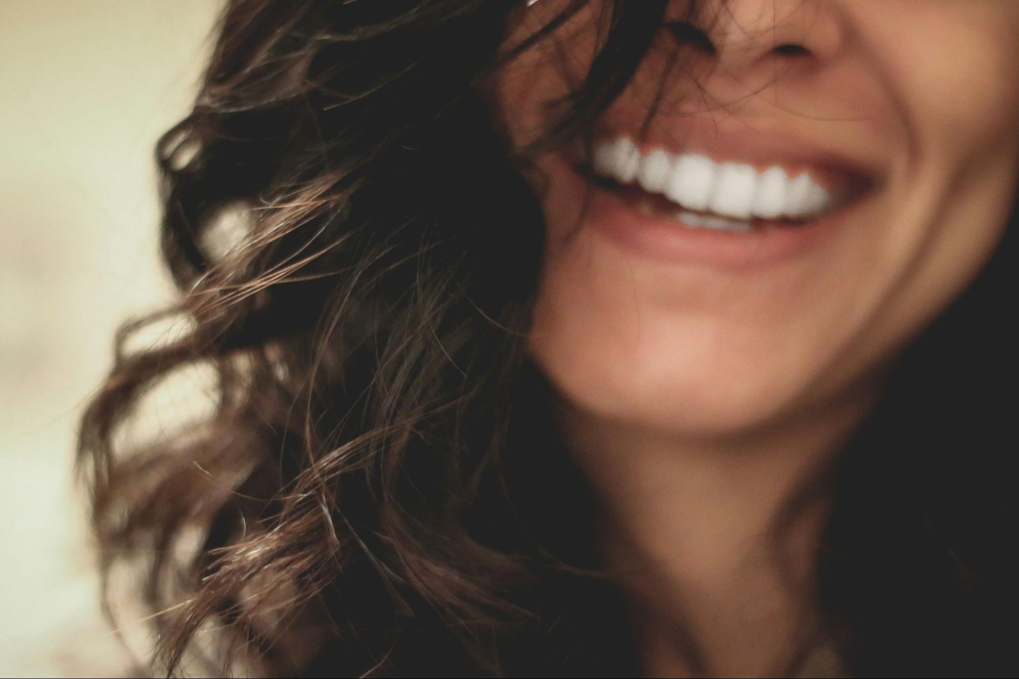 Close-up of a woman smiling with bright, white teeth, representing cosmetic dentistry results
